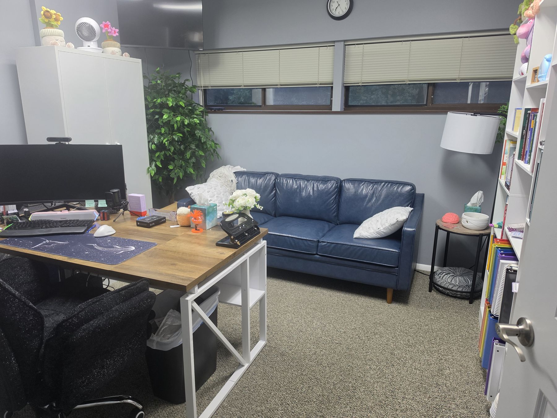 A provider office with a leather sofa, a desk and a bookshelf