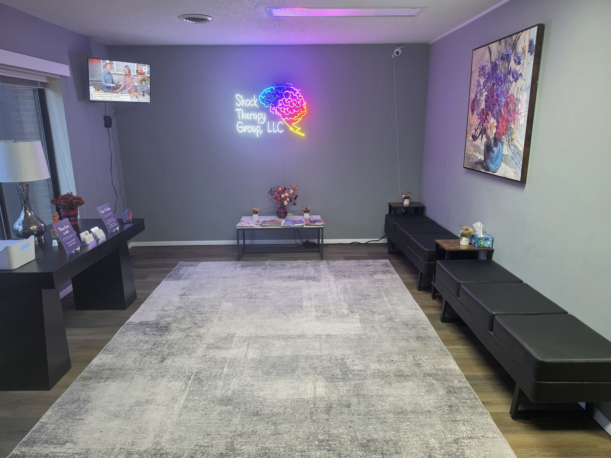 The waiting room, with the Shock Therapy Group neon sign on the far wall